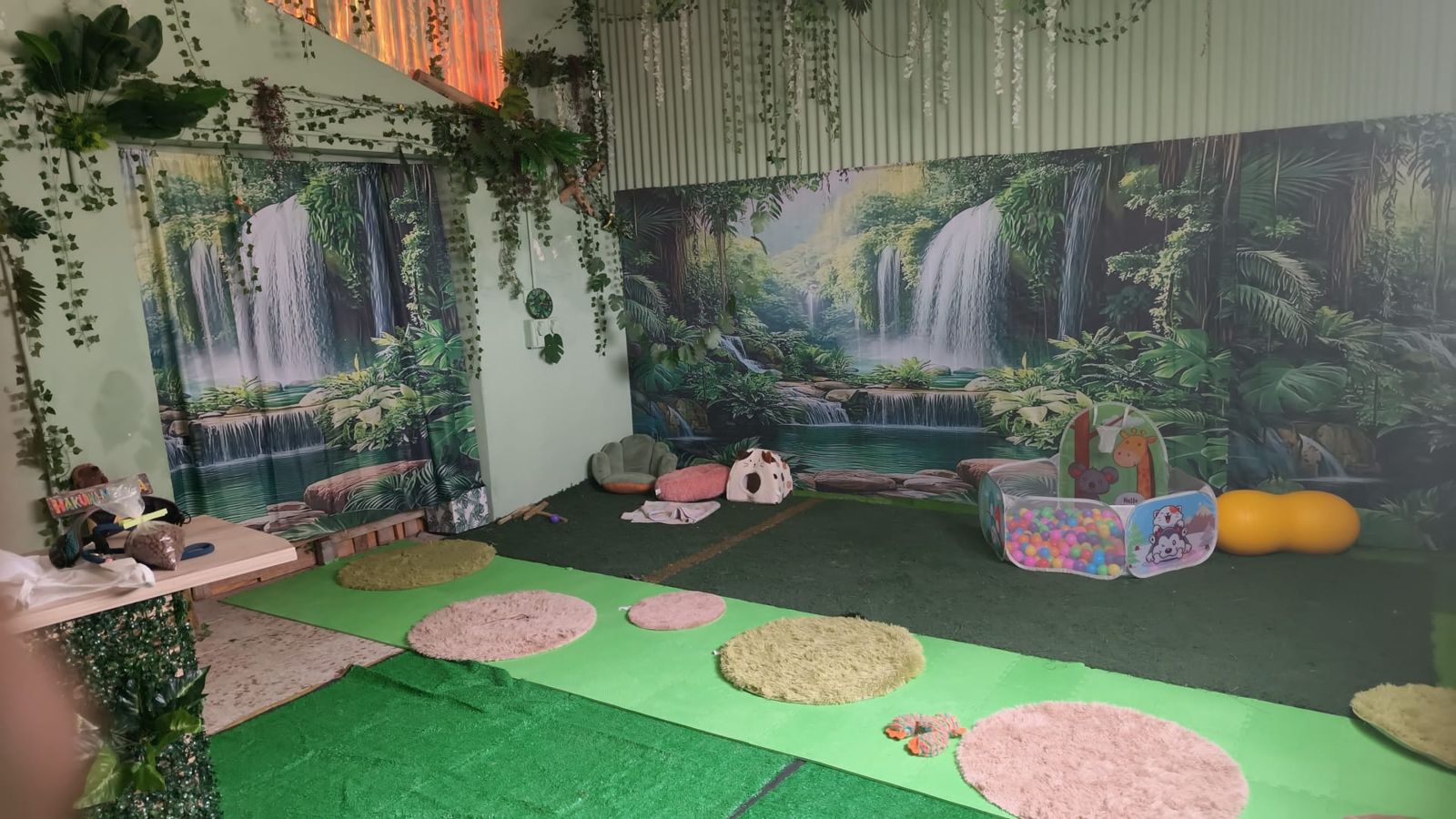 Sala de BaluLand con paisaje de cascada y vegetación